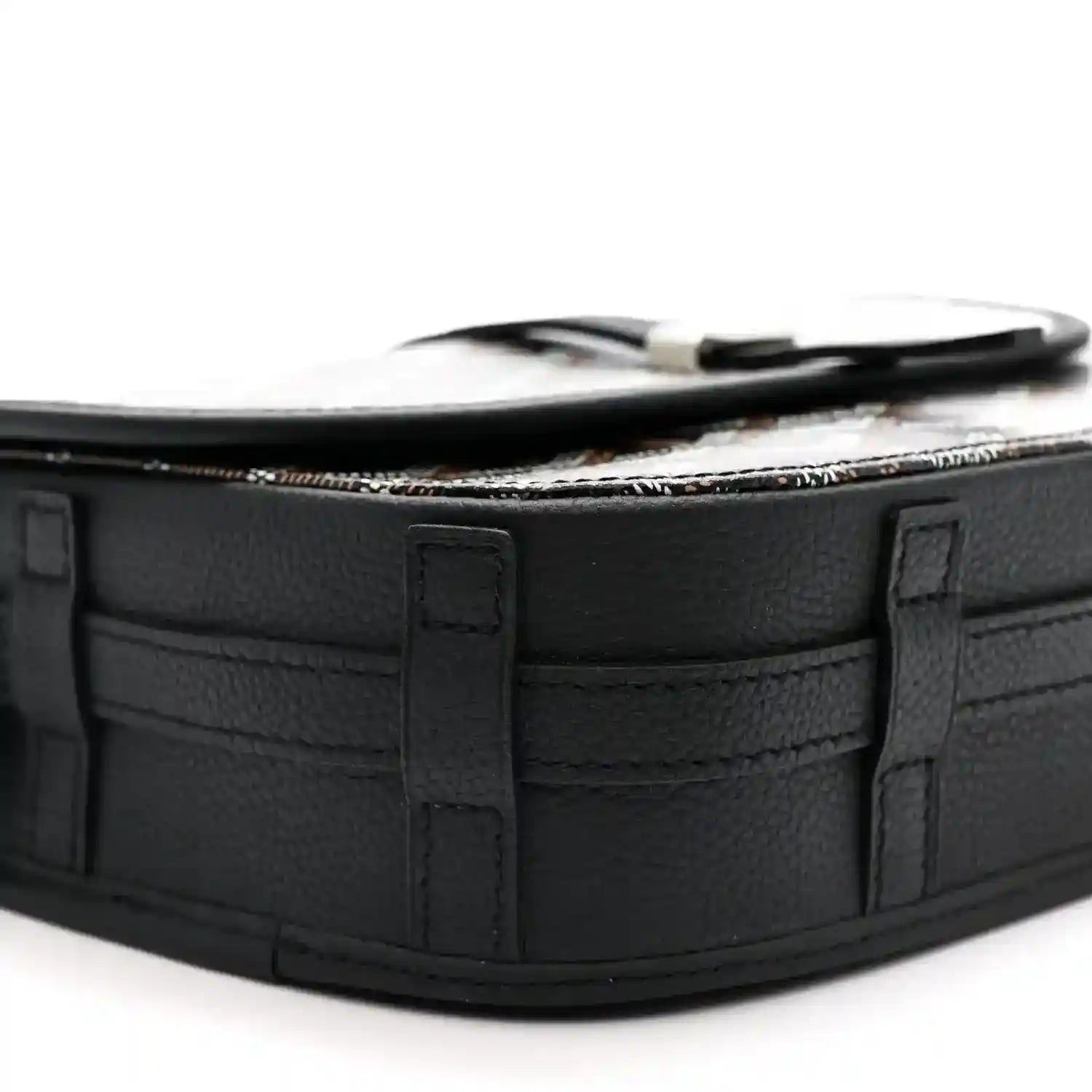 Black leather messenger bag corner with top strap loop and structured paneling