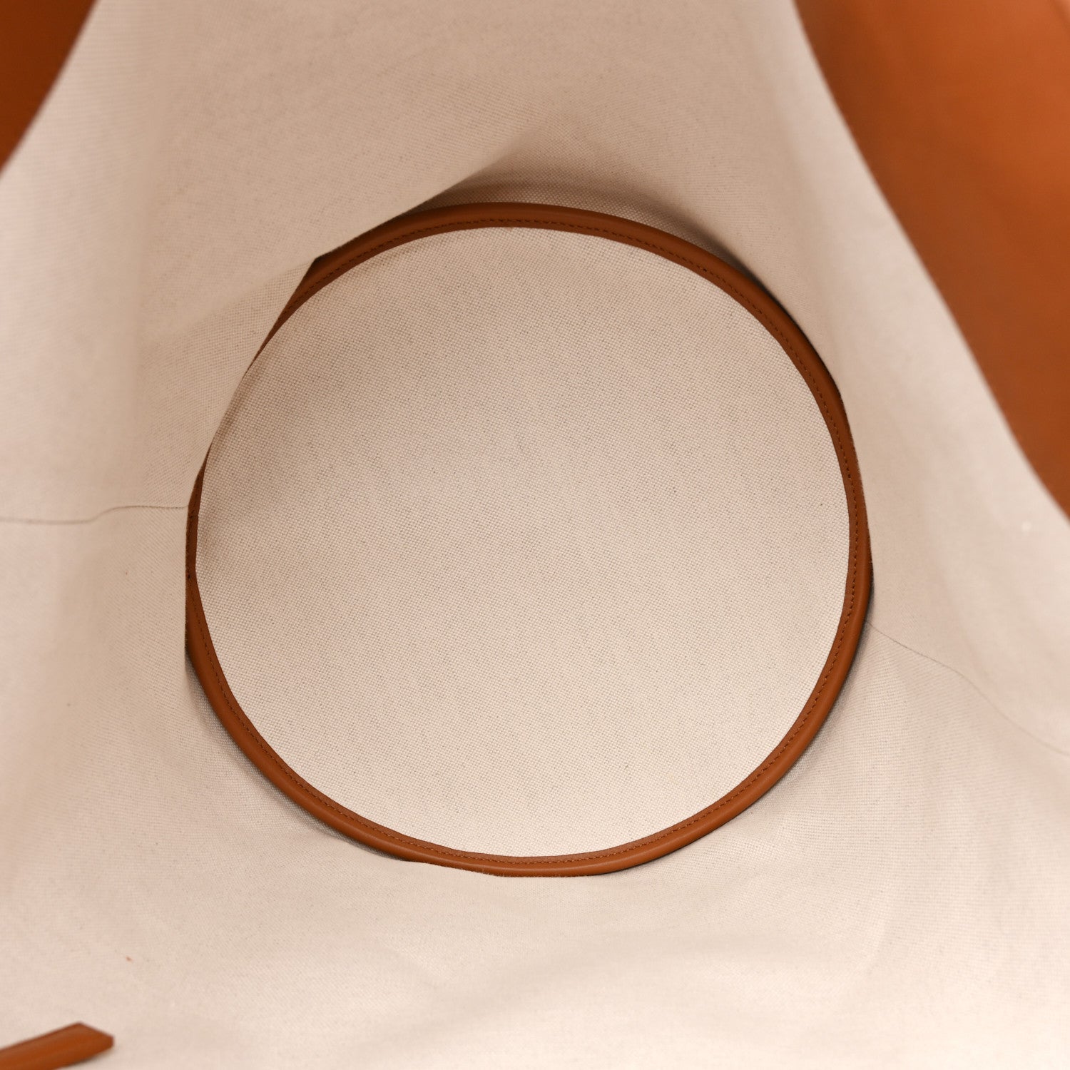 Round brown leather handle trim on desert dust canvas tote