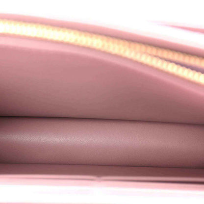 Closeup of purple leather flap and gold-tone chain edge detailing