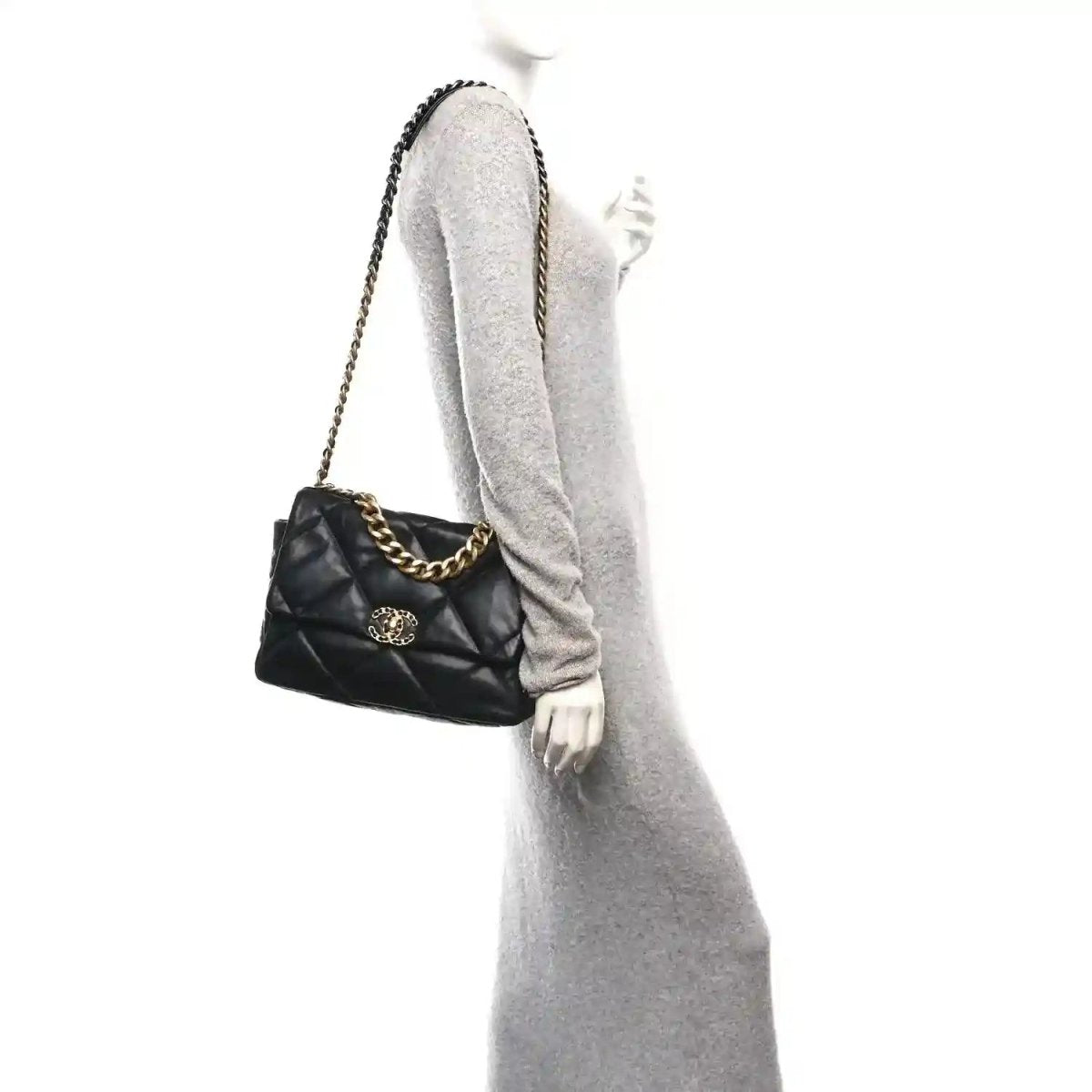 Black quilted leather flap bag worn on shoulder, gold-tone chain and logo