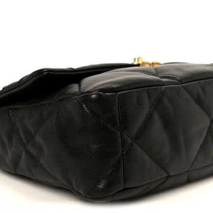 Black quilted leather flap bag side view with turn-lock hardware