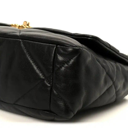Black quilted leather flap bag corner detail with diamond stitching and trim