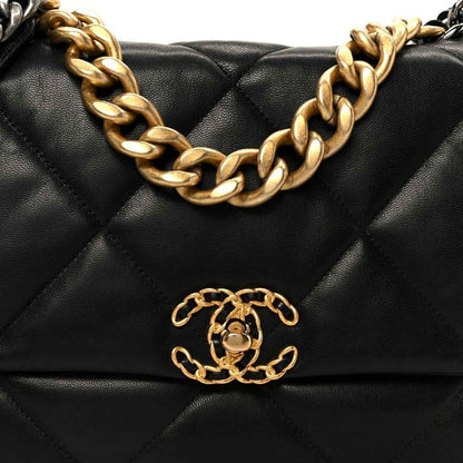 Black quilted leather flap bag front detail with gold-tone chain and logo clasp