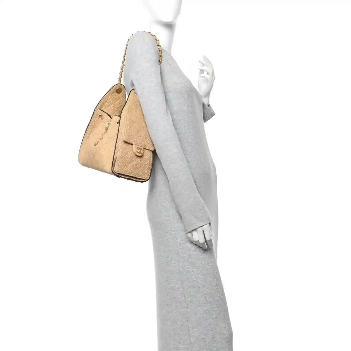 Beige braided raffia handbag with black trim, worn on model with short chain strap