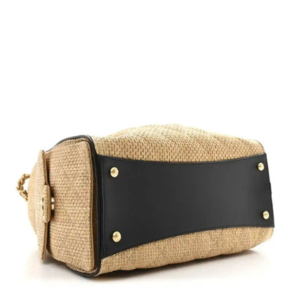 Beige raffia handbag with black leather strap panel and metal snap studs