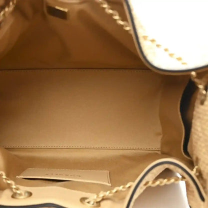 Beige leather-lined handbag interior with stitched seam and side pocket panel