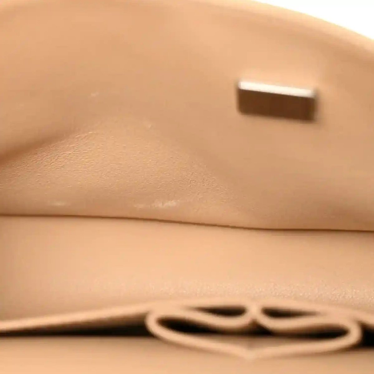 Beige caviar-quilted flap shoulder bag close-up with gold-tone chain detail