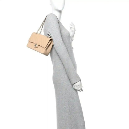 Chanel beige quilted caviar shoulder bag with chain strap, shown on a model