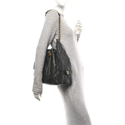 Black quilted leather bucket-style handbag with chain strap and gold hardware