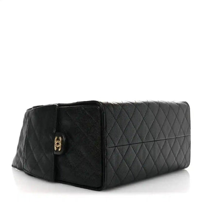 Black quilted leather shoulder bag with front clasp and gold emblem
