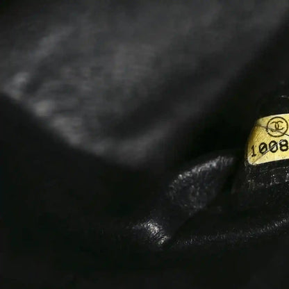 Black caviar leather quilted bag corner detail with gold-toned hardware stamp