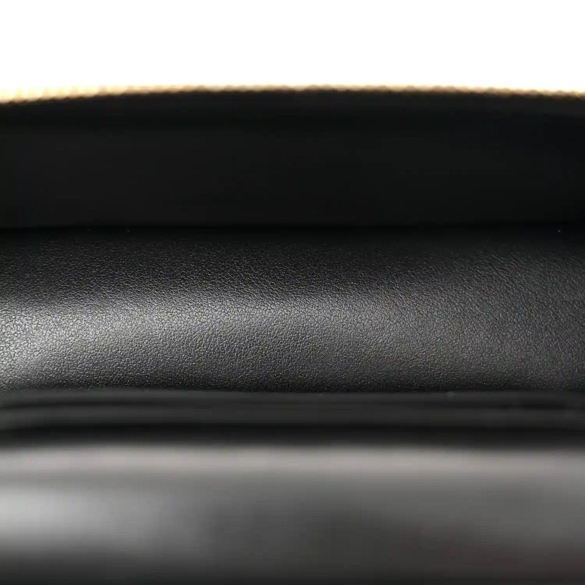 Black quilted leather with fine pebble texture, close-up