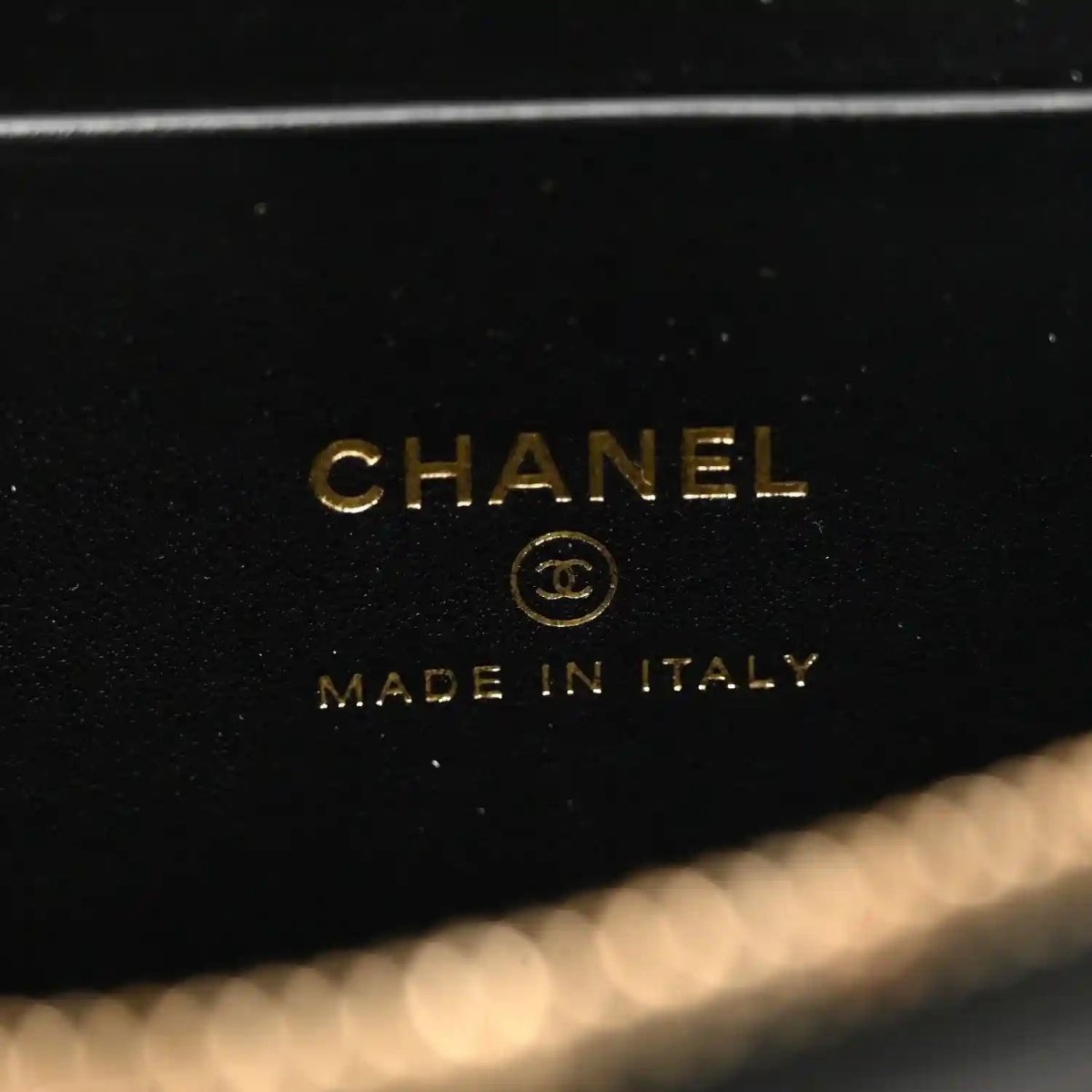 Black leather vanity bag with embossed text: CHANEL and MADE IN ITALY