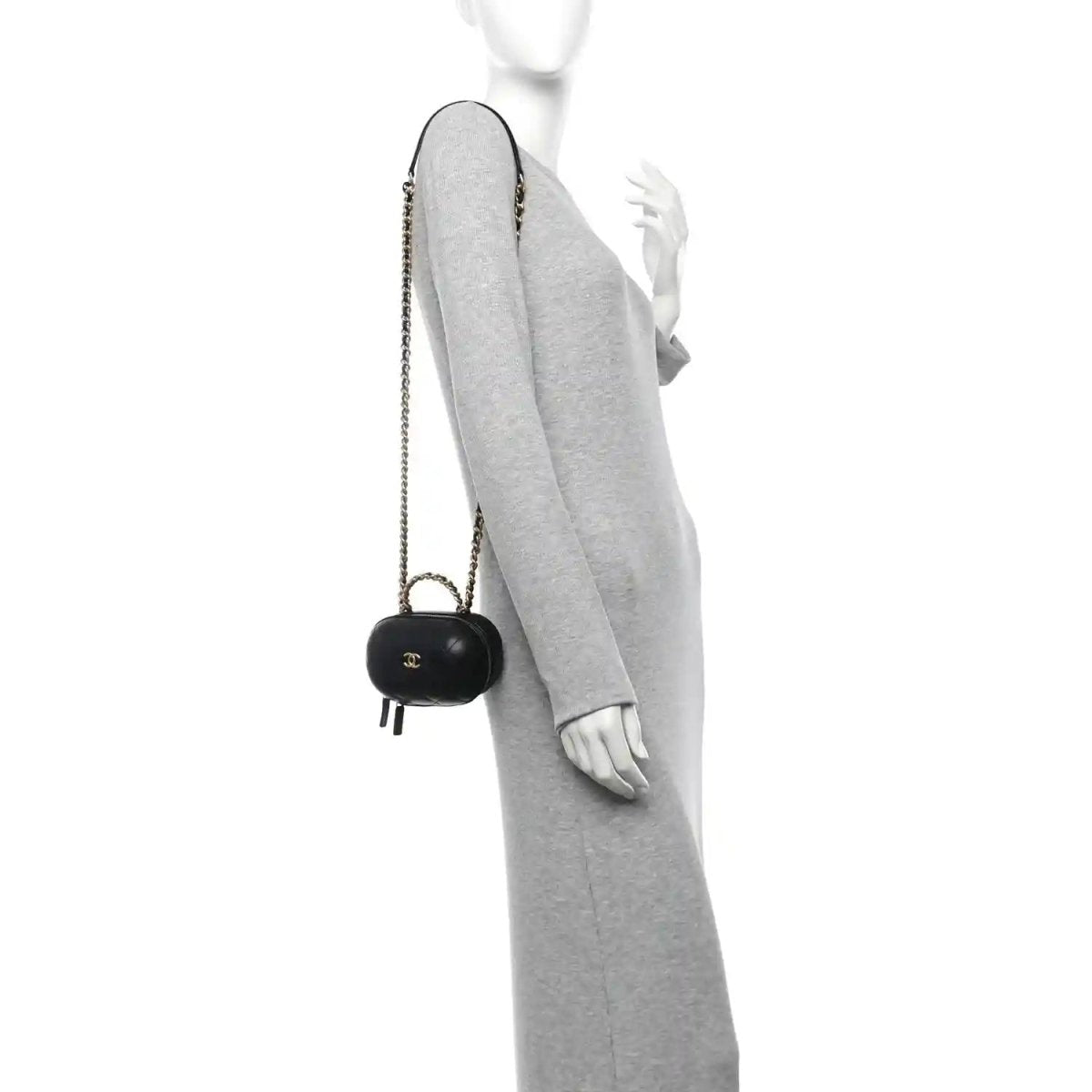 Black chain vanity case with gold CC logo, carried crossbody on a person