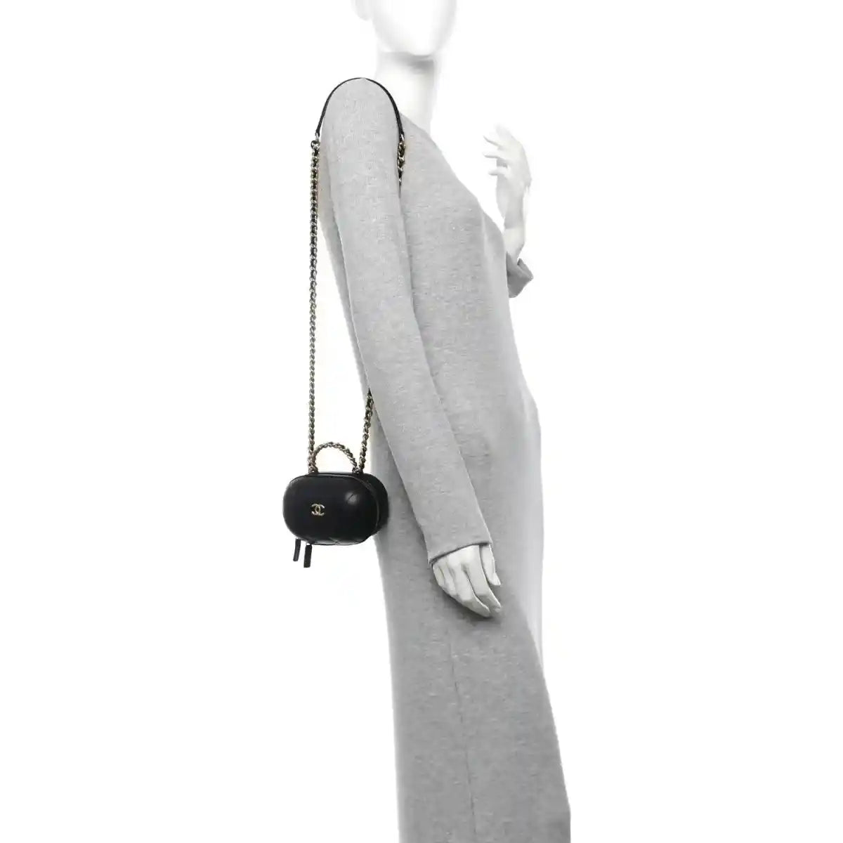 Black chain vanity case with gold CC logo, carried crossbody on a person