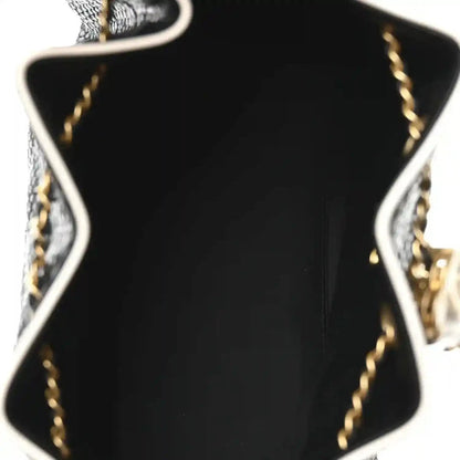 Chanel small handbag close-up, black interior panel with white trim and gold chain