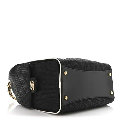 Chanel small handbag side view, black textured body with gold stud accents and tab