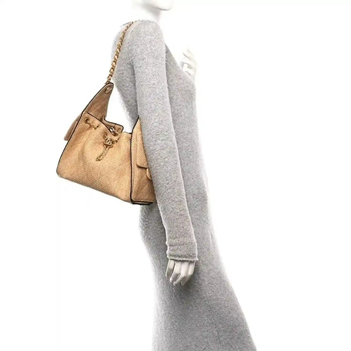 Beige raffia small handbag with braided chain strap and black trim, worn at side