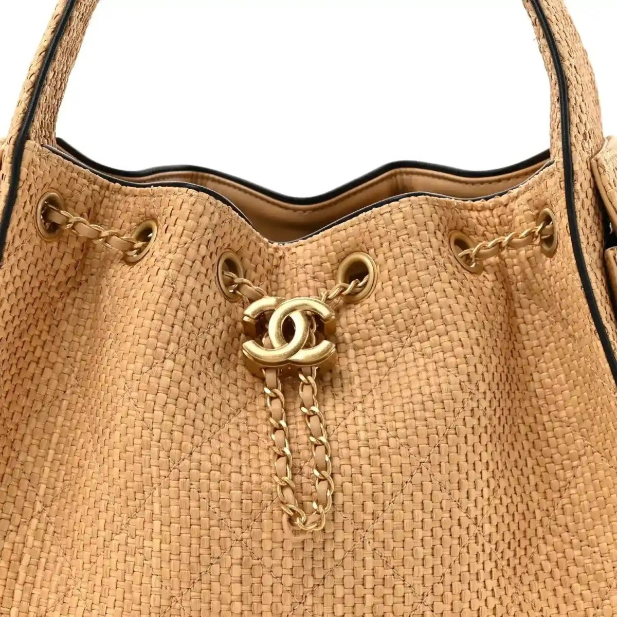 Beige raffia top opening of small handbag with gold CC pull and chain drawcord