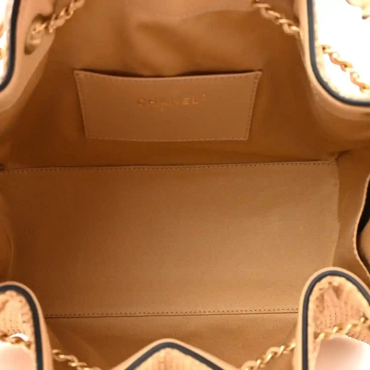 Small handbag interior with tan fabric lining and stitched leather Chanel label