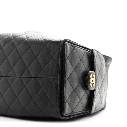 Quilted caviar leather handbag with gold-tone clasp detail and black leather panels