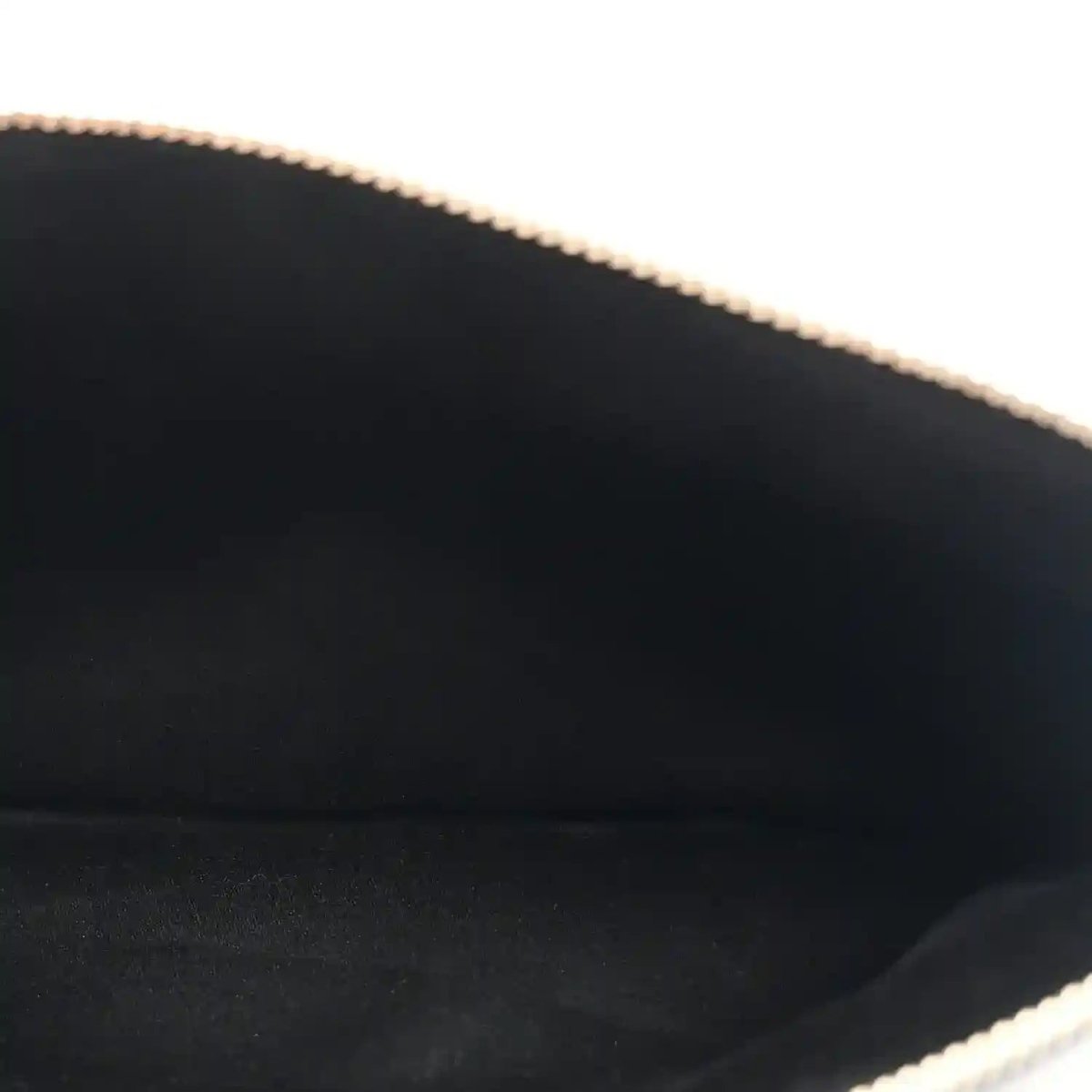 Close-up of handbag interior edge with gold-tone chain trim