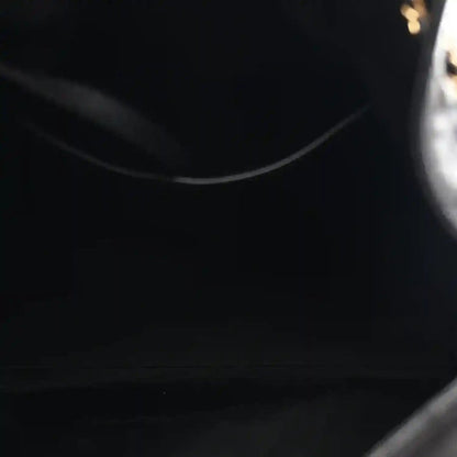 Black leather interior curve with visible stitching along the handbag opening