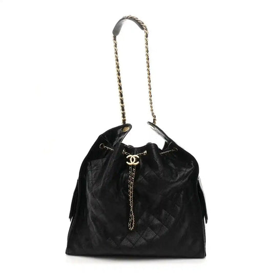 Black quilted leather handbag with chain handles, CC logo, and tassel accents