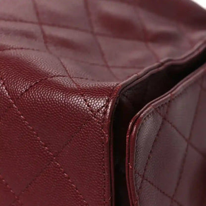 Burgundy quilted caviar flap bag corner with leather edge trim and inner lining visible
