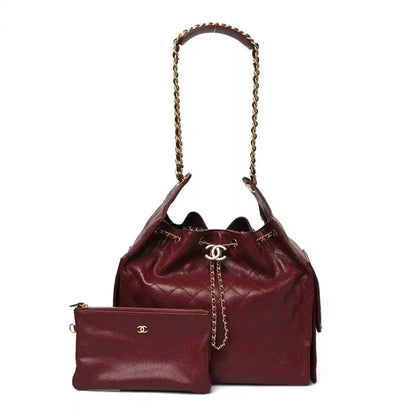 Burgundy quilted Chanel bag with chain handle, CC clasp, and front pocket