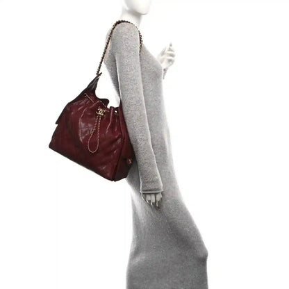 Burgundy quilted Chanel flap bag with chain shoulder strap and CC detail