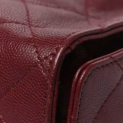 Burgundy caviar quilted flap bag corner with stitched leather edge and dark interior