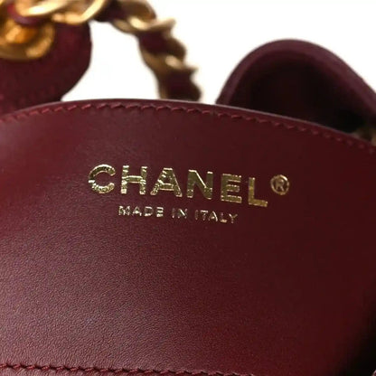 Chanel logo on burgundy leather flap of quilted bag, gold-tone emblem