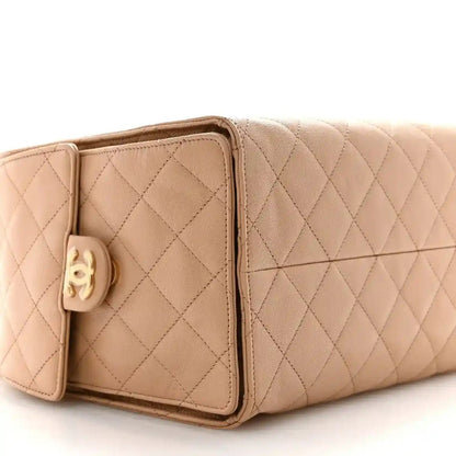 Beige quilted leather handbag with flap pocket and gold hardware at front