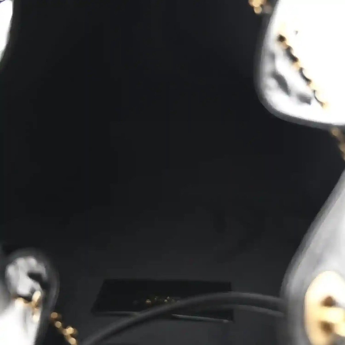 Black handbag interior lining edge with gold hardware and chain ring detail