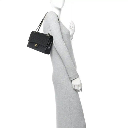 Chanel caviar quilted bag carried by a model with short gold chain strap