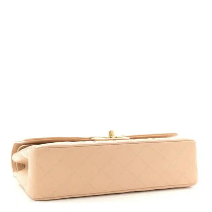 Beige quilted leather double flap bag shown from the side with top edge