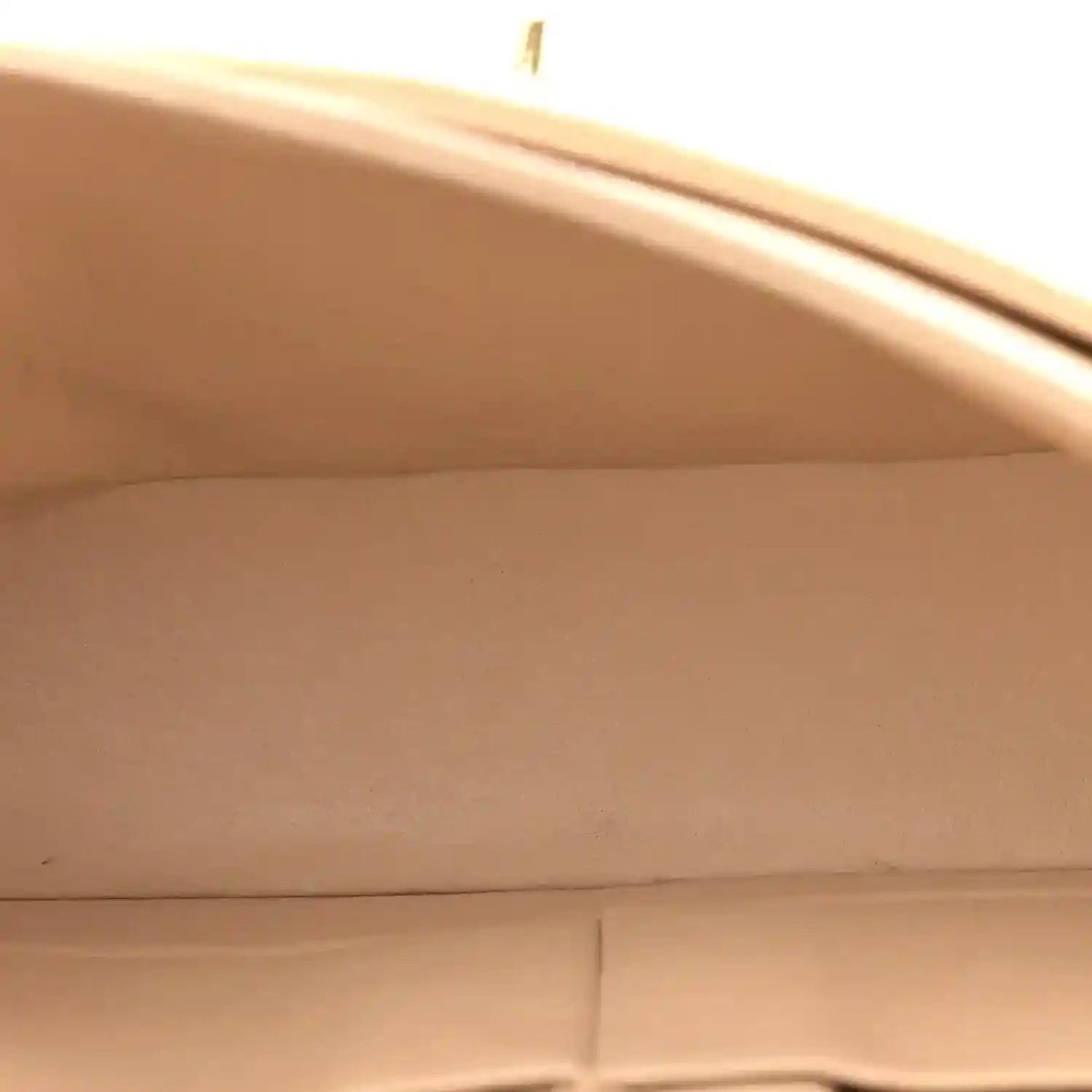 Beige leather interior lining with stitched seams of a quilted double flap bag