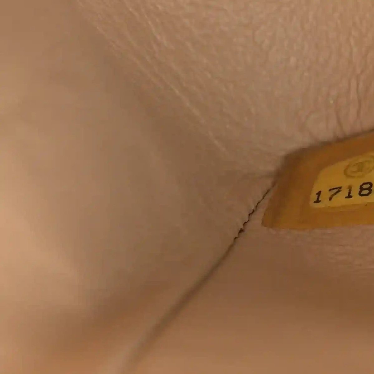 Beige leather bag interior with small yellow label showing number 1718