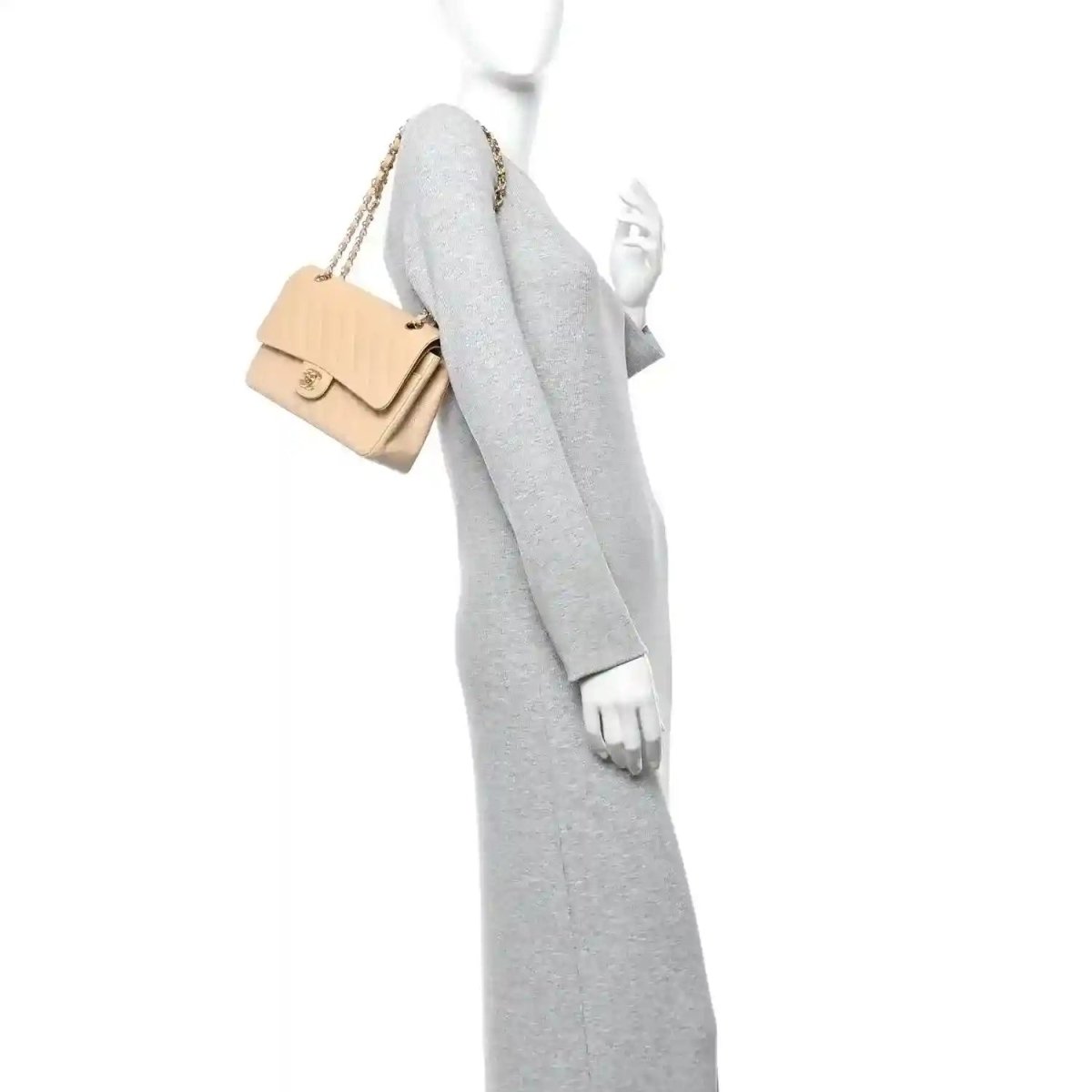 Beige quilted double flap bag with chain strap, held on a mannequin