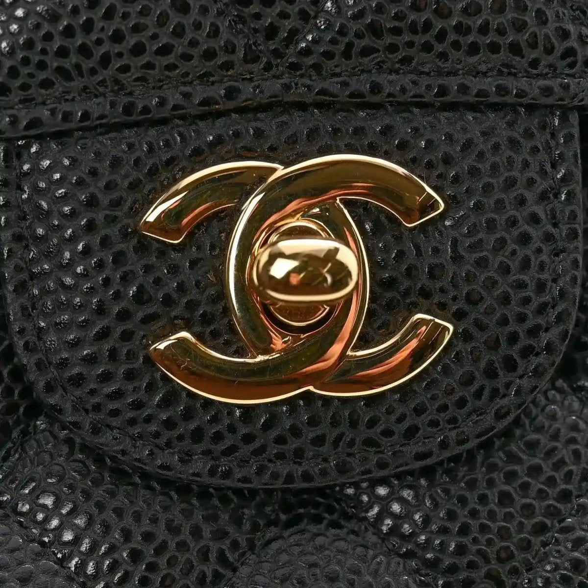 Chanel CC logo medallion on black caviar quilted flap