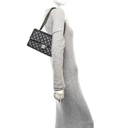 Quilted caviar leather shoulder bag with gold chain and CC clasp, held on arm