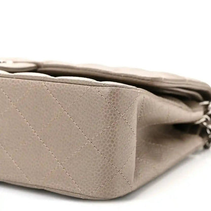 Taupe quilted leather flap bag side view with silver chain strap and stitched panels