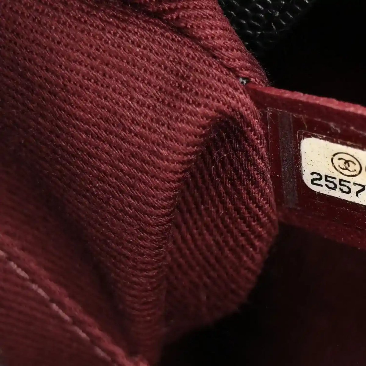 Burgundy interior pocket seam with fabric tag showing printed code 2557.