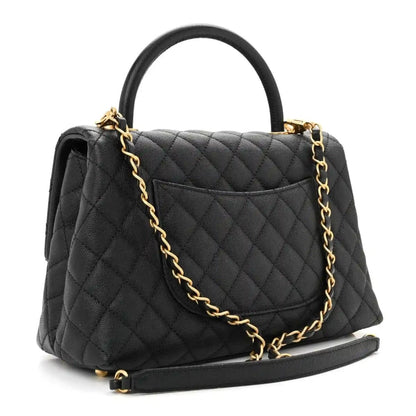 Black quilted small flap bag with gold chain strap and front flap overhang.