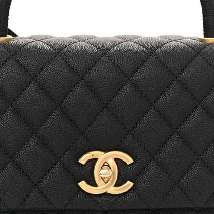 Black quilted leather flap bag with gold Chanel CC logo on the front flap.