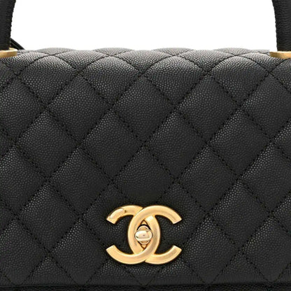 Black quilted leather flap bag with gold Chanel CC logo on the front flap.