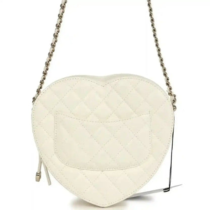 White quilted heart-shaped shoulder bag with flap seam details and chain strap, gold hardware