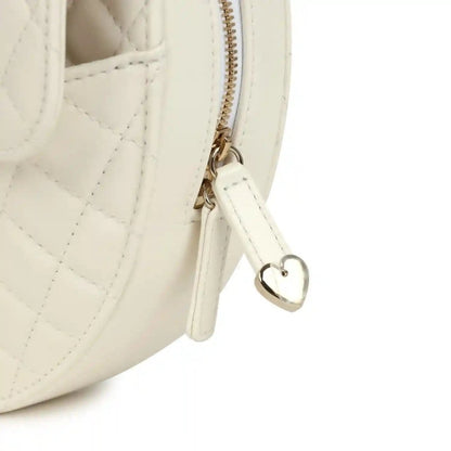 White quilted heart bag close-up of top zipper and heart-shaped charm on gold hardware