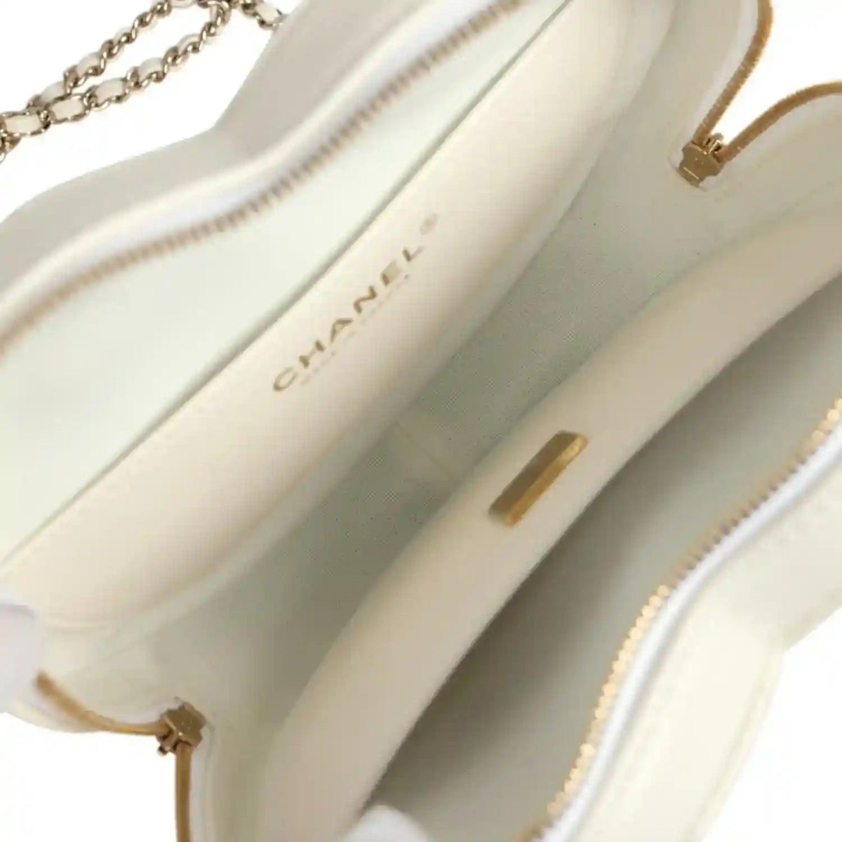 White interior lining close-up with Chanel label and gold-tone hardware accents